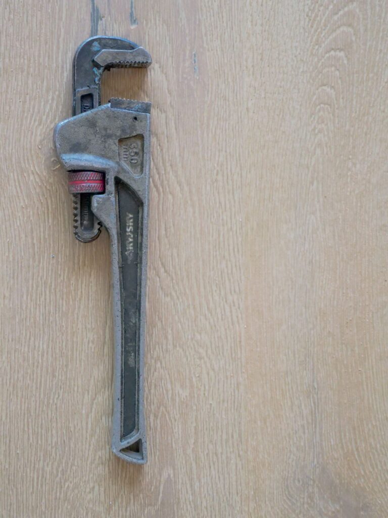 Pipe wrench tool on a wood surface