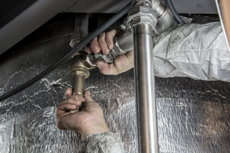 Plumber installing pipes for water heater replacement